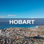 Aerial view of Hobart, Tasmania, showcasing the city’s waterfront, historic buildings, and surrounding landscape, highlighting urban development and scenic beauty.