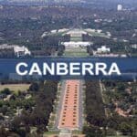 Aerial view of Canberra featuring Parliament House, lush gardens, and city skyline, showcasing Australia's capital city’s iconic landmarks and green spaces.